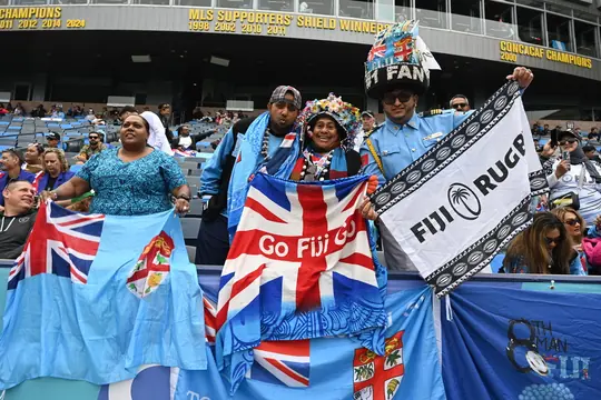 Fiji fans in the stands with flags and a Fiji Rugby banner