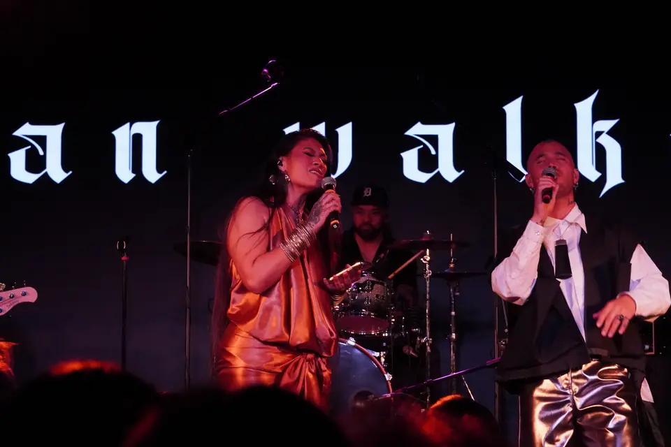 Band performing live under red stage lights