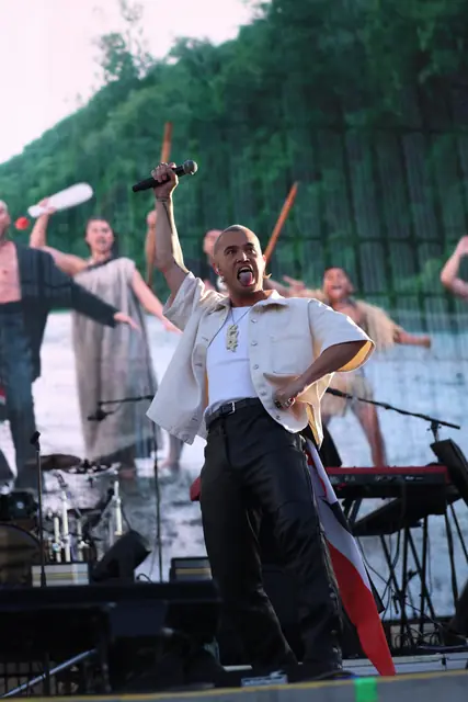 Artist performing on stage in front of dancers