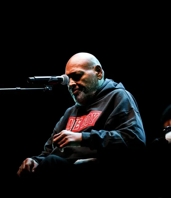 Singer performing seated under a single spotlight