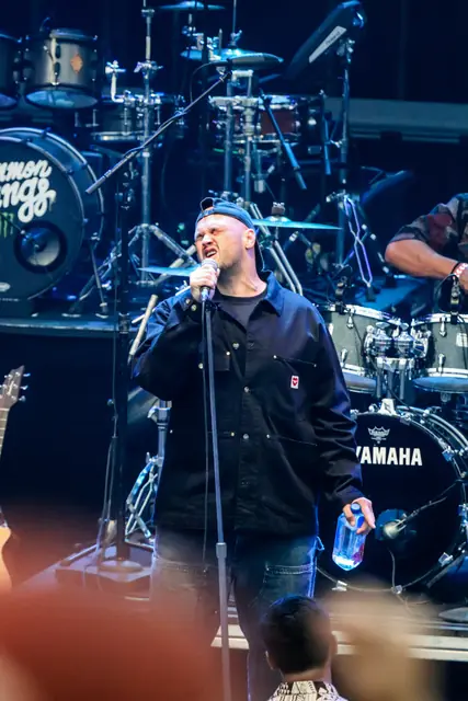 Singer fronting the band under blue lights