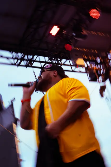 Singer in a yellow shirt performing on stage