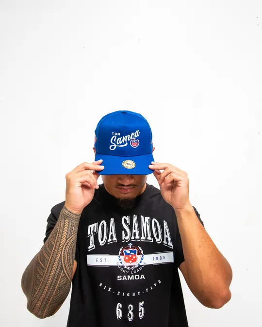 Model tipping a blue Toa Samoa cap over his eyes